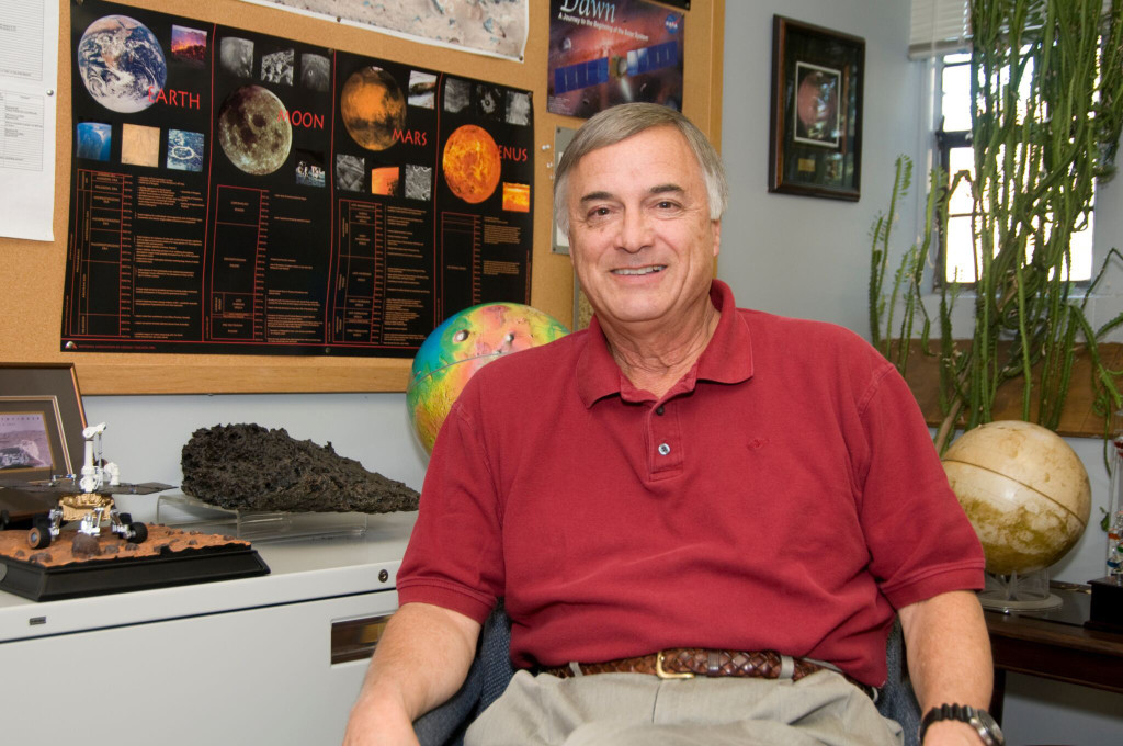 Hap McSween in his office, with a planetary chart and a model of Mars behind him