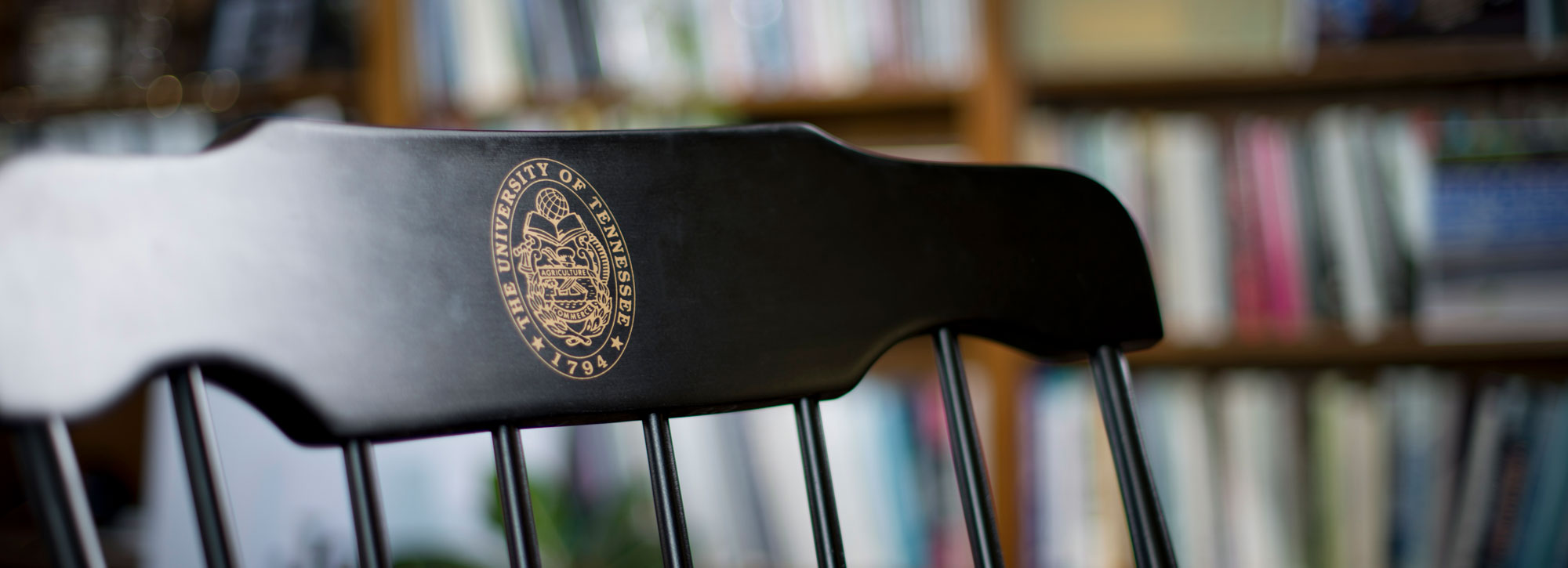 black mahogany chair in the president's office with gold university seal